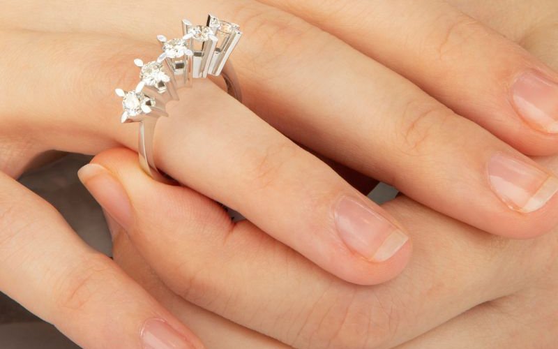 a women is wearing large 5 stone eternity ring